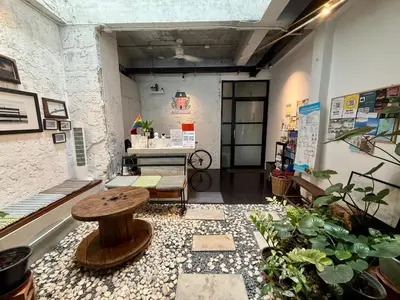 a room filled with lots of plants and a table at Niece Hostel Phuket - Bangtao Beach in Ban Thalat Choeng Thale
