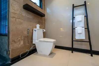 a bathroom with a toilet and a shower with towels at The Harmony Pool Villa Phuket in Bang Tao Beach