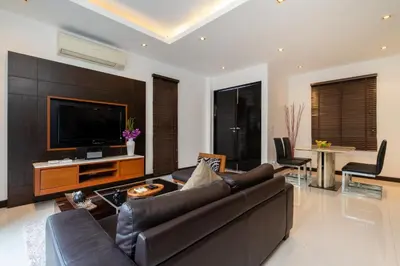 a living room with a couch and a flat screen tv at The Harmony Pool Villa Phuket in Bang Tao Beach