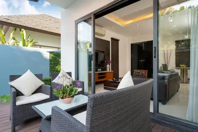 an outdoor patio with chairs and a table at The Harmony Pool Villa Phuket in Bang Tao Beach