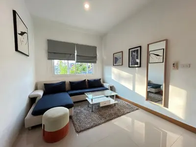 a living room with a blue couch and a mirror at Clear House Resort - SHA Extra Plus in Kamala Beach