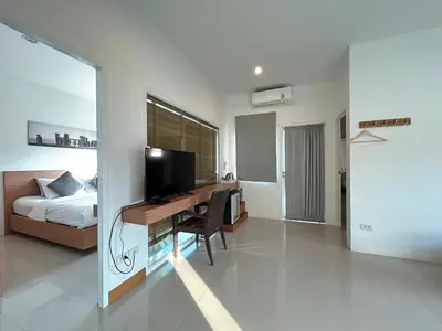 a bedroom with a desk with a television and a bed at Clear House Resort - SHA Extra Plus in Kamala Beach
