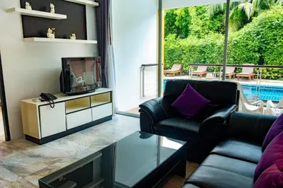 a living room with a tv and a couch at Rawai Paradise in Rawai Beach