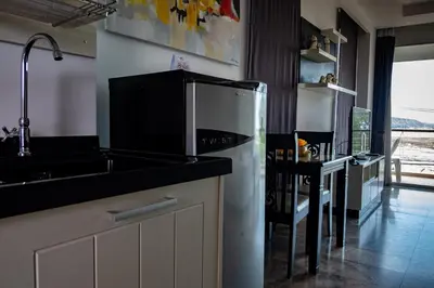 a kitchen with a microwave and a sink and a table at Rawai Paradise in Rawai Beach