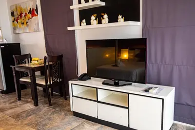 a living room with a tv on a white entertainment center at Rawai Paradise in Rawai Beach