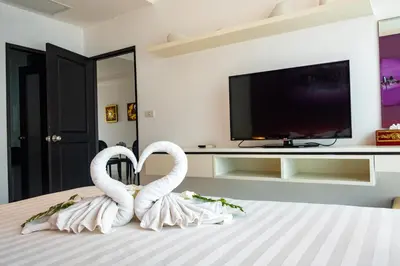 two white swans sitting on top of a bed at Rawai Paradise in Rawai Beach