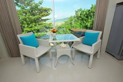 a patio with a glass table and two chairs at Chalong Beach Front Residence in Rawai Beach