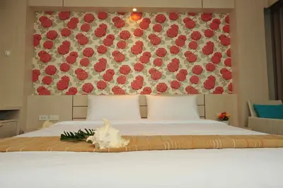 a bedroom with a bed with a flower arrangement on it at Chalong Beach Front Residence in Rawai Beach