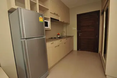a kitchen with a stainless steel refrigerator and a door at Chalong Beach Front Residence in Rawai Beach