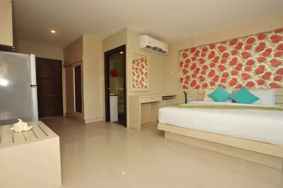 a large bedroom with a bed and a refrigerator at Chalong Beach Front Residence in Rawai Beach