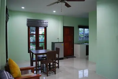 a kitchen with a table and chairs in a room at Anacar Bungalows in Krabi town