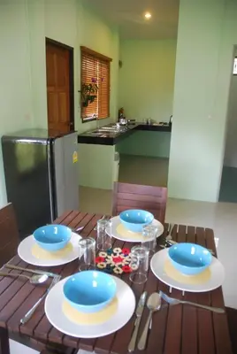 a wooden table with blue and white plates on it at Anacar Bungalows in Krabi town