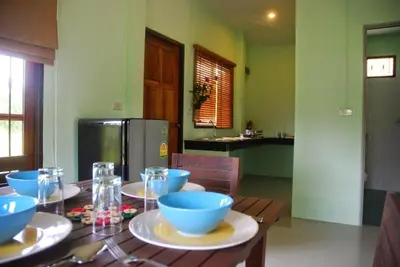 a kitchen with a wooden table with blue bowls on it at Anacar Bungalows in Krabi town