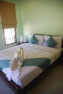 a large bed with a stuffed animal laying on it at Anacar Bungalows in Krabi town