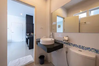 a bathroom with a toilet and a sink and a mirror at May House Karon Beach in Karon Beach