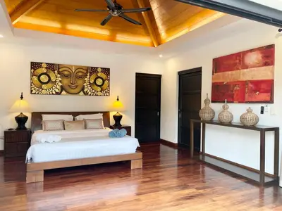 a bedroom with a bed and a ceiling fan at Villa Suksan - Kubu in Nai Harn Beach