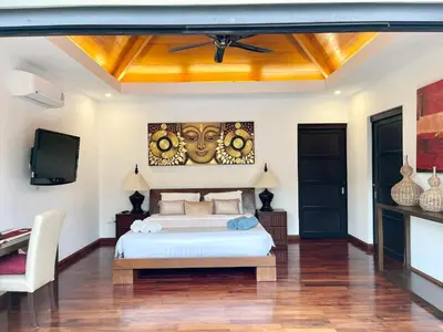 a bedroom with a bed and a flat screen tv at Villa Suksan - Kubu in Nai Harn Beach