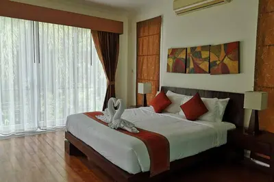 a bedroom with a large bed with a large window at 4 Bedroom Villa Kamala Beach Phuket in Kamala Beach