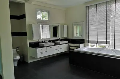 a bathroom with a tub and two sinks and a toilet at 4 Bedroom Villa Kamala Beach Phuket in Kamala Beach