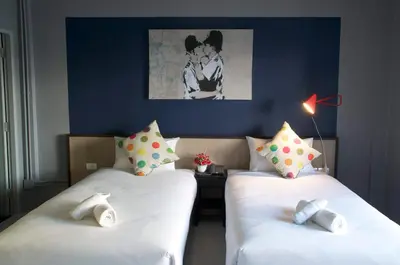two beds in a room with blue walls at Chalong Sea Breeze in Chalong