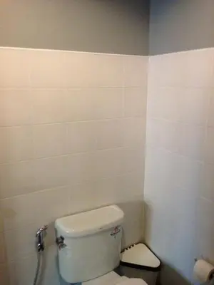 a bathroom with a white toilet in a room at Chalong Sea Breeze in Chalong