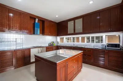 a large kitchen with wooden cabinets and a counter top at Phuket Pool Villa Sea view at town in Phuket Town