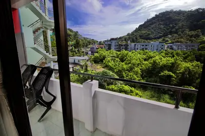 a balcony with a bench and a view of a city at The Little Moon Residence in Patong Beach