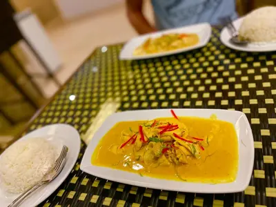 a plate of food on a table with rice at The Little Moon Residence in Patong Beach