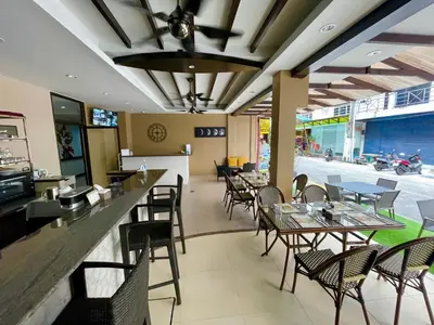 a restaurant with tables and chairs and a bar at The Little Moon Residence in Patong Beach