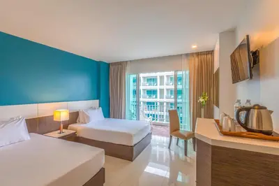 a hotel room with two beds and a window at Chanalai Hillside Resort, Karon Beach in Karon Beach