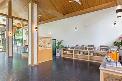 a restaurant with wooden ceilings and a dining area at Lady Naya Villas - SHA Extra Plus in Rawai Beach