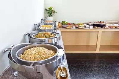a buffet with three trays of food on a counter at Lady Naya Villas - SHA Extra Plus in Rawai Beach