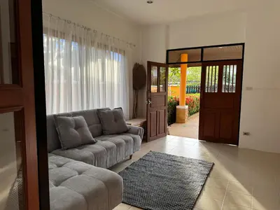 a living room with a couch and a door at The Orange Villa Near Beach \u6642\u5c1a\u5bb6\u5ead\u5225\u5885\u63d0\u4f9b\u514d\u8cbb\u63a5\u9001\u670d\u52d9 in Kamala Beach