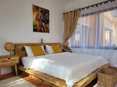 a bedroom with a bed with yellow pillows and a window at The Orange Villa Near Beach \u6642\u5c1a\u5bb6\u5ead\u5225\u5885\u63d0\u4f9b\u514d\u8cbb\u63a5\u9001\u670d\u52d9 in Kamala Beach