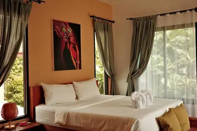 a bedroom with a bed and a large window at The Orange Villa Near Beach \u6642\u5c1a\u5bb6\u5ead\u5225\u5885\u63d0\u4f9b\u514d\u8cbb\u63a5\u9001\u670d\u52d9 in Kamala Beach