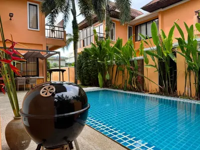 a swimming pool in front of a building with a pool at The Orange Villa Near Beach \u6642\u5c1a\u5bb6\u5ead\u5225\u5885\u63d0\u4f9b\u514d\u8cbb\u63a5\u9001\u670d\u52d9 in Kamala Beach