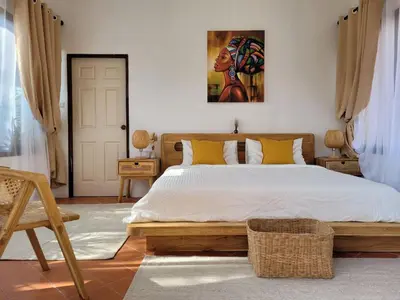 a bedroom with a large bed with yellow pillows at The Orange Villa Near Beach \u6642\u5c1a\u5bb6\u5ead\u5225\u5885\u63d0\u4f9b\u514d\u8cbb\u63a5\u9001\u670d\u52d9 in Kamala Beach
