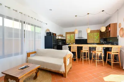 a living room with a couch and a kitchen at The Orange Villa Near Beach \u6642\u5c1a\u5bb6\u5ead\u5225\u5885\u63d0\u4f9b\u514d\u8cbb\u63a5\u9001\u670d\u52d9 in Kamala Beach