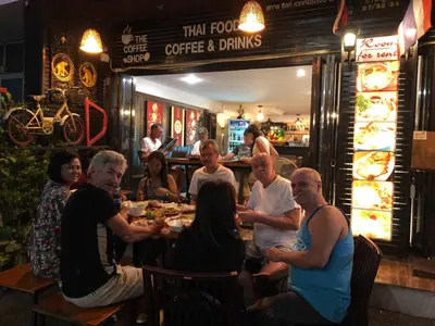 a group of people sitting at a table in a restaurant at Sky Silk Decoration House in Patong Beach