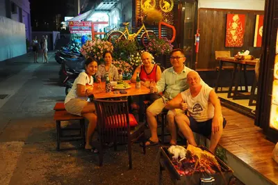 a group of people sitting at a table in a restaurant at Sky Silk Decoration House in Patong Beach