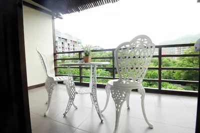 two chairs and a table on a balcony at Sky Silk Decoration House in Patong Beach