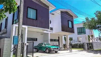 a green truck parked in front of a building at Happy Family Villa in Phuket Town