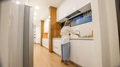 a woman standing in a kitchen preparing food at Happy Family Villa in Phuket Town