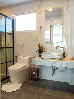 a bathroom with a toilet and a sink and a mirror at Peranakan House in Phuket Town