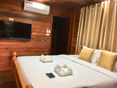 a bedroom with two beds and a tv on a wall at Life and Love house in Ban Na Noi