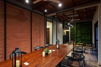 a large wooden table in a room with a brick wall at P2 Wood Loft in Phi Phi Don