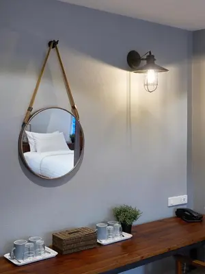 a mirror on a wall above a table with a bed at P2 Wood Loft in Phi Phi Don