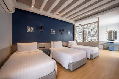 a bedroom with two beds and a blue wall at Seabed Grand Hotel Phuket in Phuket Town