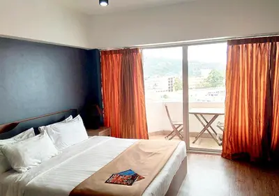 a bedroom with a bed and a balcony with a table at Studio Sea View Patong in Patong Beach