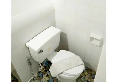 a bathroom with a white toilet with a towel on it at Studio Sea View Patong in Patong Beach